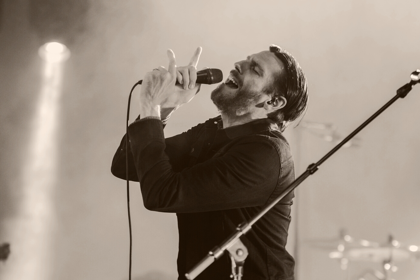 Man Wearing Black Collared Long Sleeve Shirt Holding Microphone